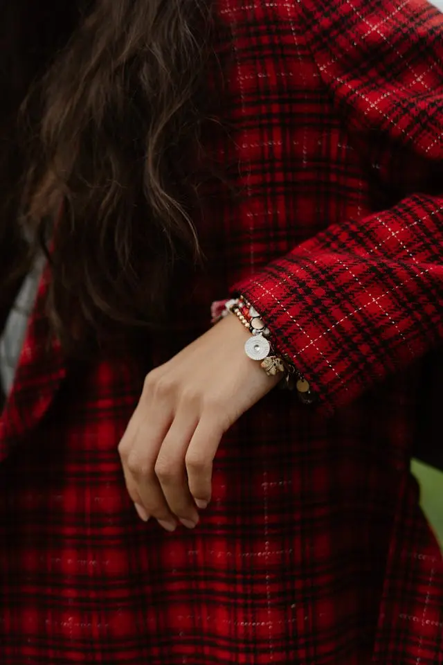 Détail de manche en tissu tartan rouge montrant un raccord de carreaux réussi en couture