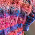 Gros plan sur les torsades du débardeur Bonny tricoté en Magnolia dégradé rose, violet et orange