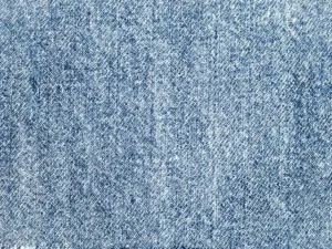 Gros plan sur un tissu denim en armure sergé montrant la diagonale caractéristique du tissage chaîne et trame